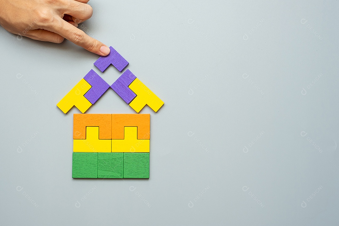 Bloco de forma em casa com peças de quebra-cabeça de madeira coloridas em fundo cinza. pensamento lógico, lógica de negócios, soluções, racional, casa