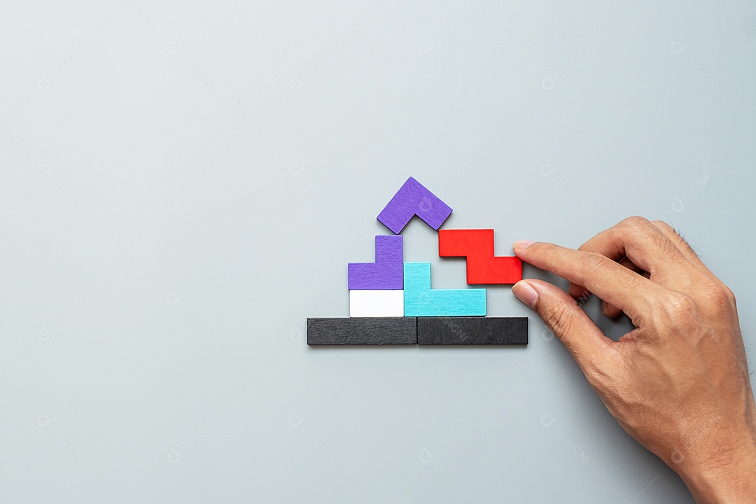 Bloco de forma em casa com peças de quebra-cabeça de madeira coloridas em fundo cinza. pensamento lógico, lógica de negócios, soluções, racional, casa