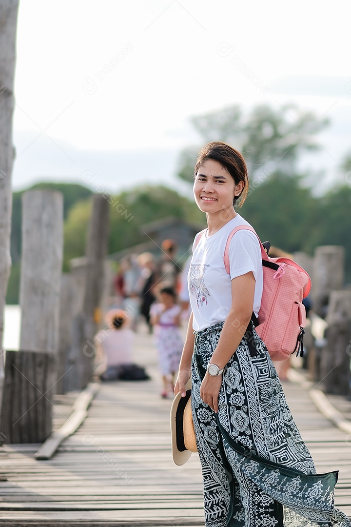 Jovem mulher andando na ponte U bein ao pôr do sol, viajante asiático viajando perto de Amarapura em Mianmar (Birmânia). Marco e popular para atrações turísticas. Conceito de viagem do Sudeste Asiático