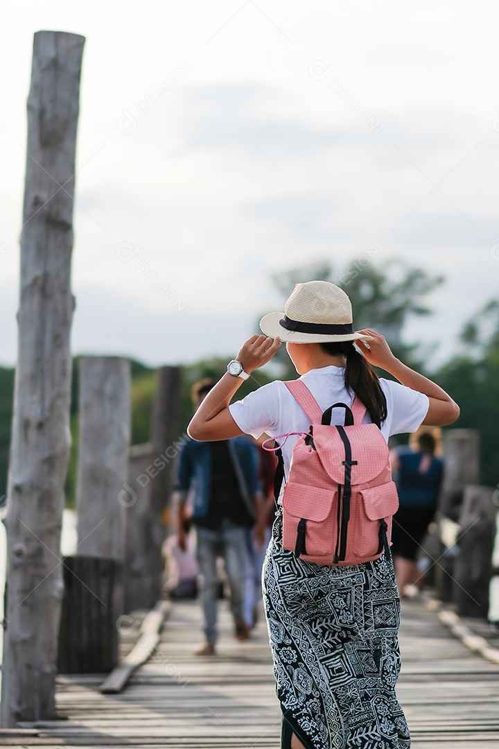 Jovem mulher andando na ponte U bein ao pôr do sol, viajante asiático viajando perto de Amarapura em Mianmar (Birmânia). Marco e popular para atrações turísticas. Conceito de viagem do Sudeste Asiático