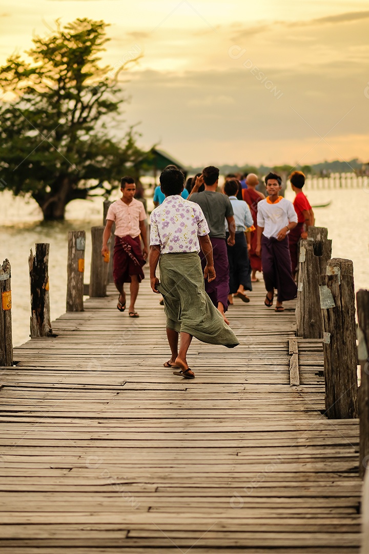 Pessoas andando na ponte U bein ao pôr do sol, é uma travessia que atravessa o Lago Taungthaman, perto de Amarapura, em Mianmar (Birmânia)