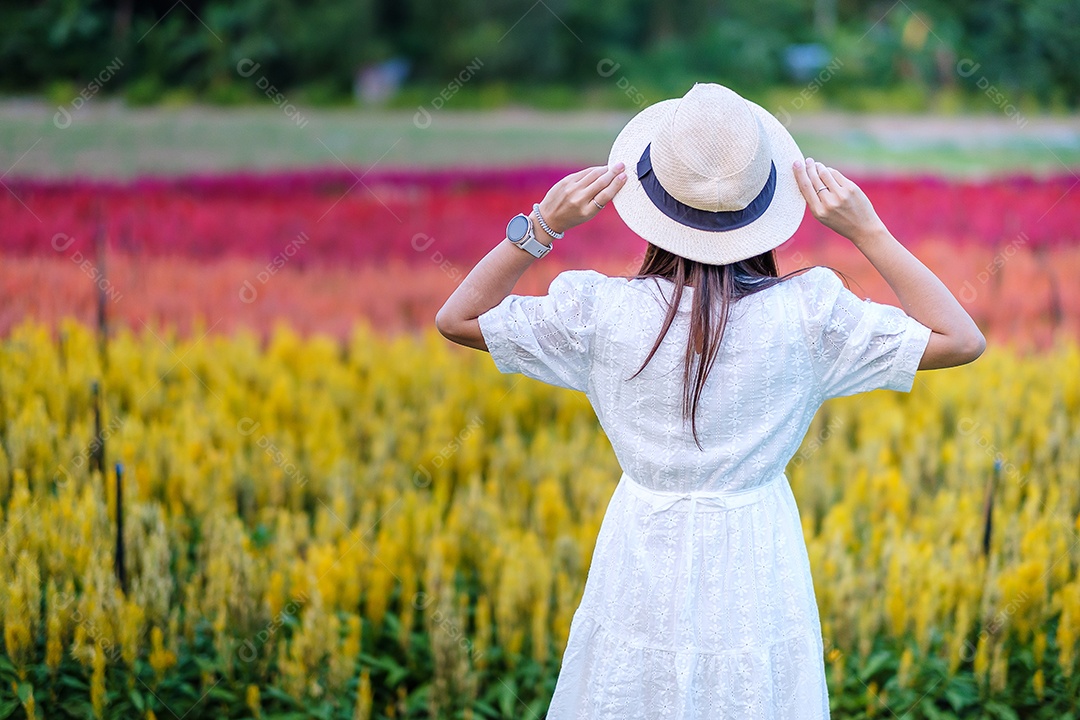 Mulher turista feliz em vestido branco desfrutar de belo jardim de flores. viagens, natureza, férias e conceito de férias
