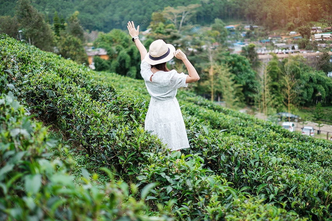 Mulher turista feliz em vestido branco desfrutar de belo jardim de flores. viagens, natureza, férias e conceito de férias