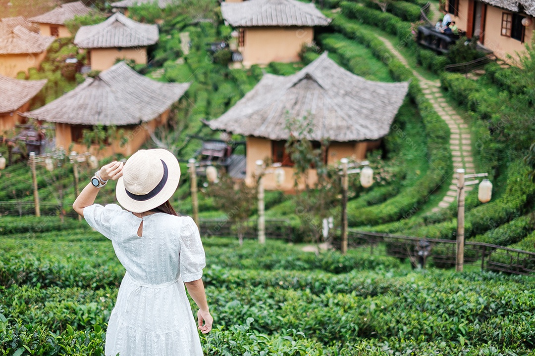 Mulher turista feliz em vestido branco desfrutar de belo jardim de flores. viagens, natureza, férias e conceito de férias