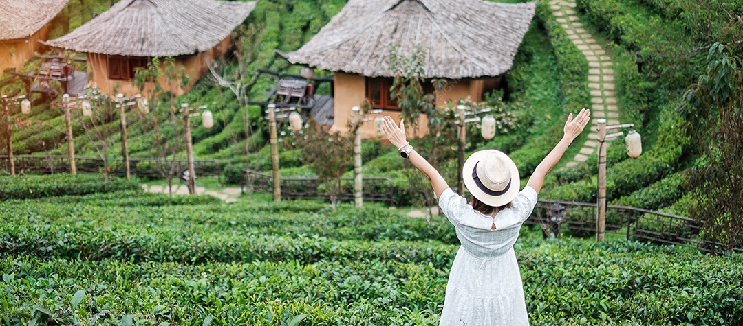 Mulher turista feliz em vestido branco desfrutar de belo jardim de flores. viagens, natureza, férias e conceito de férias
