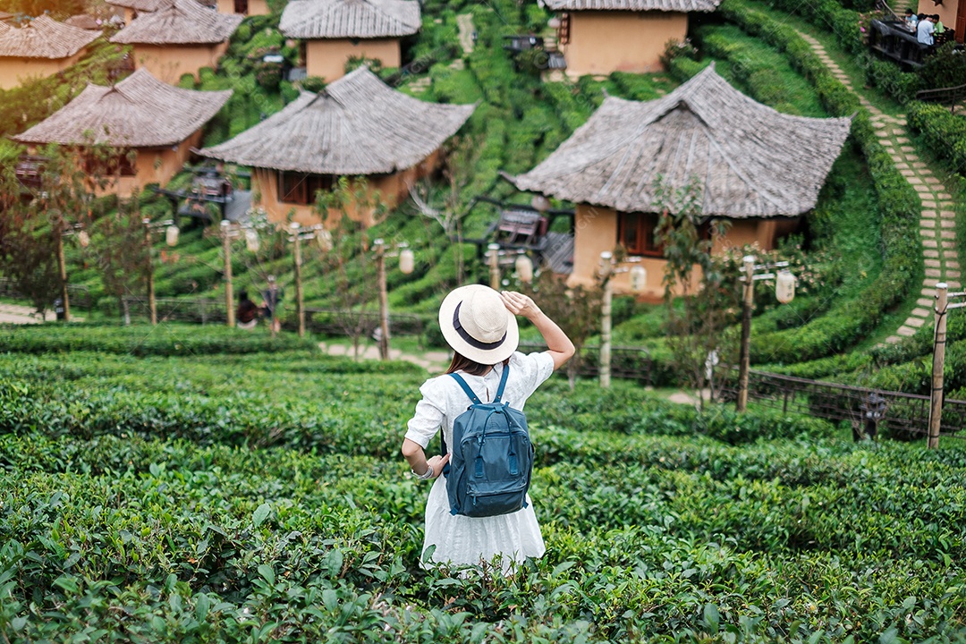 Mulher turista feliz em vestido branco desfrutar de belo jardim de flores. viagens, natureza, férias e conceito de férias