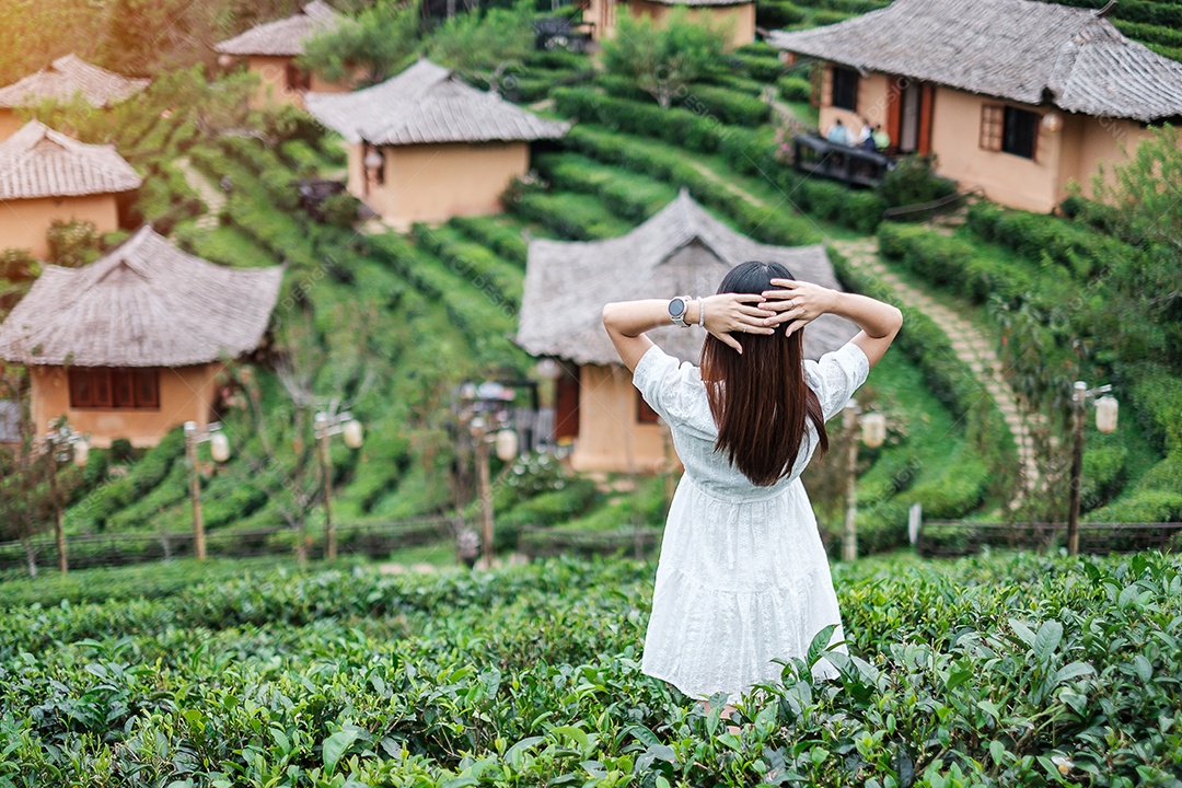 Mulher turista feliz em vestido branco desfrutar de belo jardim de flores. viagens, natureza, férias e conceito de férias