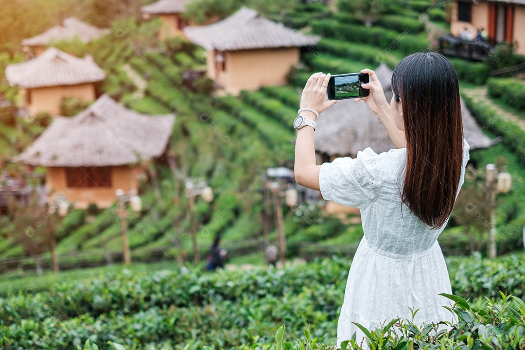Mulher turista feliz em vestido branco desfrutar de belo jardim de flores. viagens, natureza, férias e conceito de férias