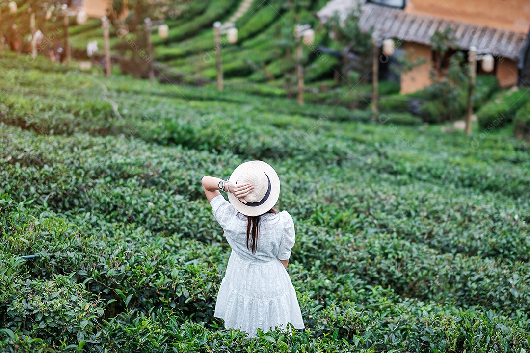 Mulher turista feliz em vestido branco desfrutar de belo jardim de flores. viagens, natureza, férias e conceito de férias