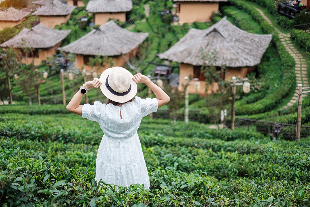 Mulher turista feliz em vestido branco desfrutar de belo jardim de chá. Viajante visitando na aldeia de Ban Rak Thai, Mae Hong Son, Tailândia. conceito de viagens