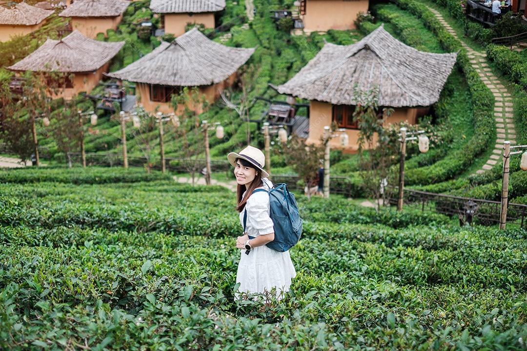 Mulher turista feliz em vestido branco desfrutar de belo jardim de chá. Viajante visitando na aldeia de Ban Rak Thai, Mae Hong Son, Tailândia. conceito de viagens