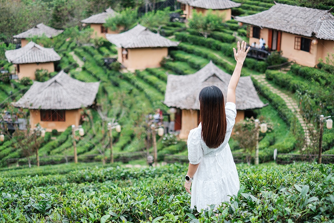 Mulher turista feliz em vestido branco desfrutar de belo jardim de chá. Viajante visitando na aldeia de Ban Rak Thai, Mae Hong Son, Tailândia. conceito de viagens