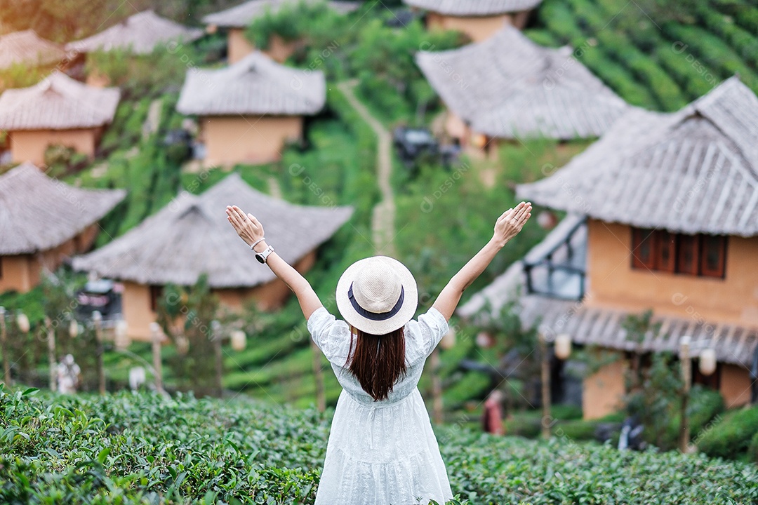 Mulher turista feliz em vestido branco desfrutar de belo jardim de chá. Viajante visitando na aldeia de Ban Rak Thai, Mae Hong Son, Tailândia. conceito de viagens, férias e férias