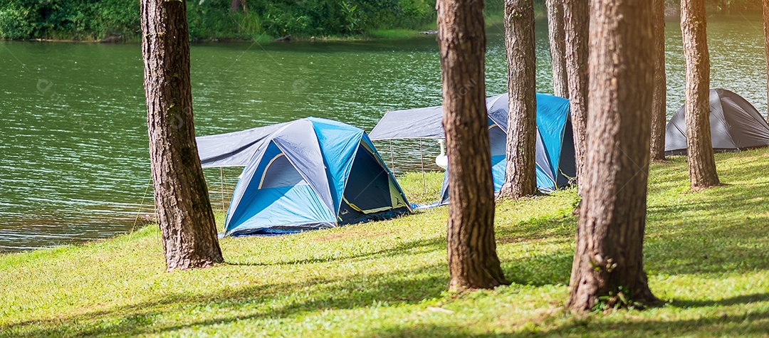 Acampar sob a floresta de pinheiros, tenda azul perto do lago em Pang Oung, Mae Hong Son, Tailândia. conceito de viagens, viagens e férias