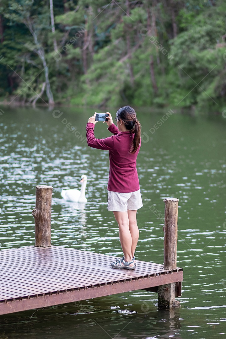 Mulher viajante feliz tirando foto vista da natureza por smartphone, turista solo em suéter viajando em Pang Oung, Mae Hong Son, Tailândia. conceito de viagens