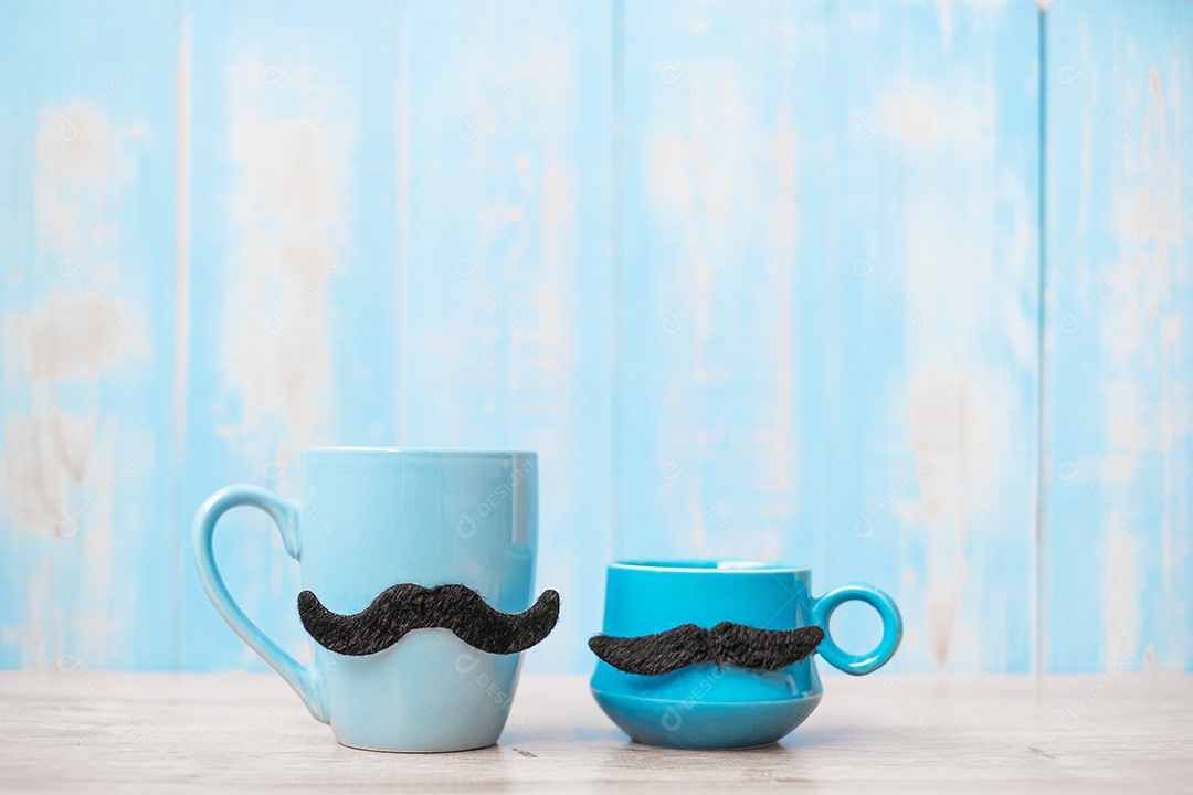 Xícaras de café azuis com bigode preto no fundo da mesa de madeira pela manhã. Dia dos pais e conceito de dia internacional dos homens