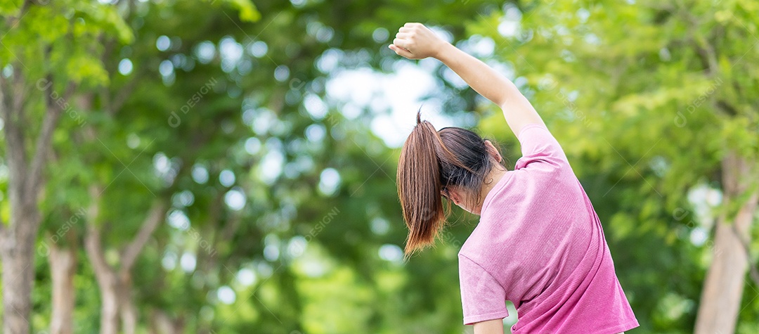 Young adult woman in pink sportswear stretching muscle.