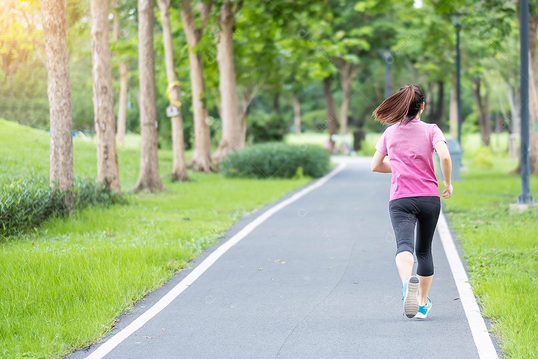 Mulher adulta jovem em roupas esportivas correndo no parque ao ar livre, mulher corredor correndo na estrada, atleta asiático andando e se exercitando de manhã. Conceitos de fitness, bem-estar, estilo de vida saudável e treino