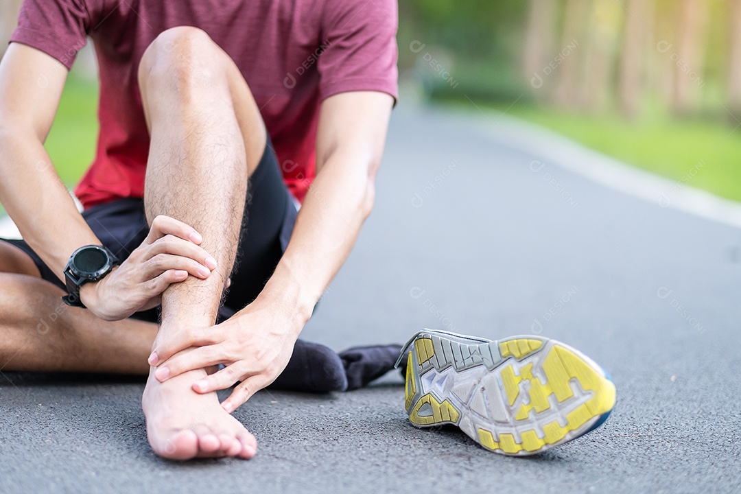 Macho adulto jovem com sua dor muscular durante a corrida. Homem corredor com dor nas pernas devido a entorses de tornozelo ou tendinite de Aquiles. Lesões esportivas e conceito médico.