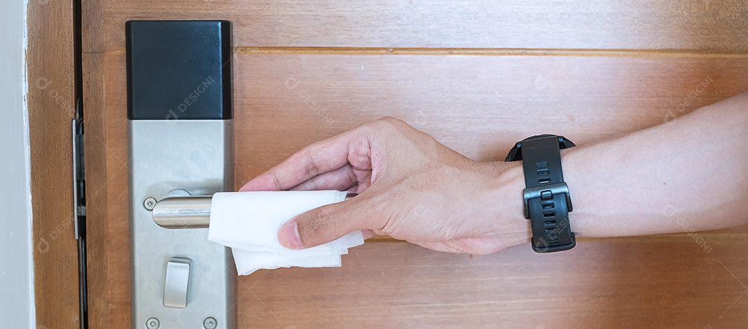 Mão de homem limpando a maçaneta da porta digital por tecido de limpeza úmida, proteção contra coronavírus ou doença do vírus Corona (Covid-19) em sala pública. Superfície limpa, estilo de vida, viagens de segurança e novo conceito normal