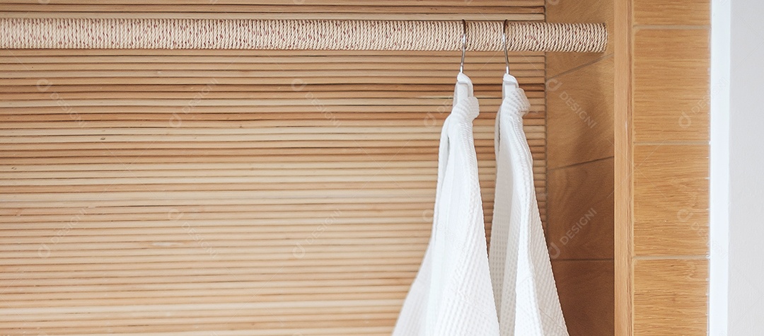Closeup roupão branco fresco pendurado no guarda-roupa de madeira no hotel de luxo. Relaxe e viaje o conceito