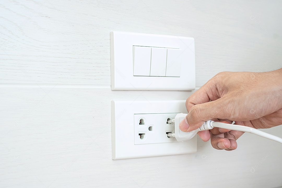 Closeup dedo masculino desconectando ou conectando o dispositivo de eletricidade na parede branca em casa. Conceitos de economia de energia, energia, eletricidade e estilo de vida