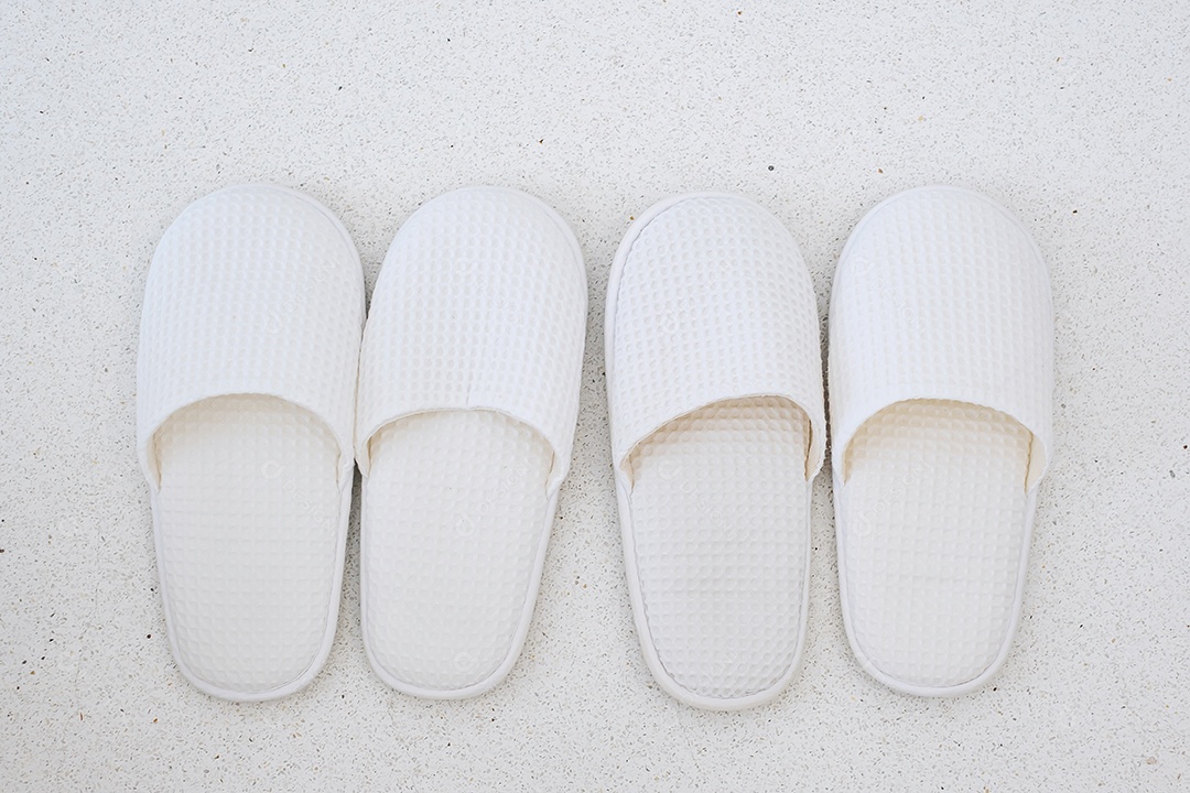 Novos chinelos brancos de suavidade no fundo do piso de mármore no hotel de luxo ou em casa moderna. Relaxe e viaje o conceito