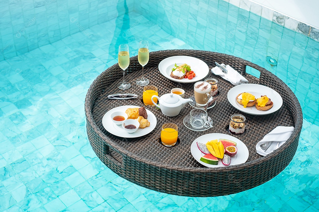 Bandeja flutuante de café da manhã na piscina no hotel de luxo ou villa de resort tropical, frutas; manga, dragão melancia e maracujá, comida, pão, café, chá, vinho e suco de laranja. verão exótico
