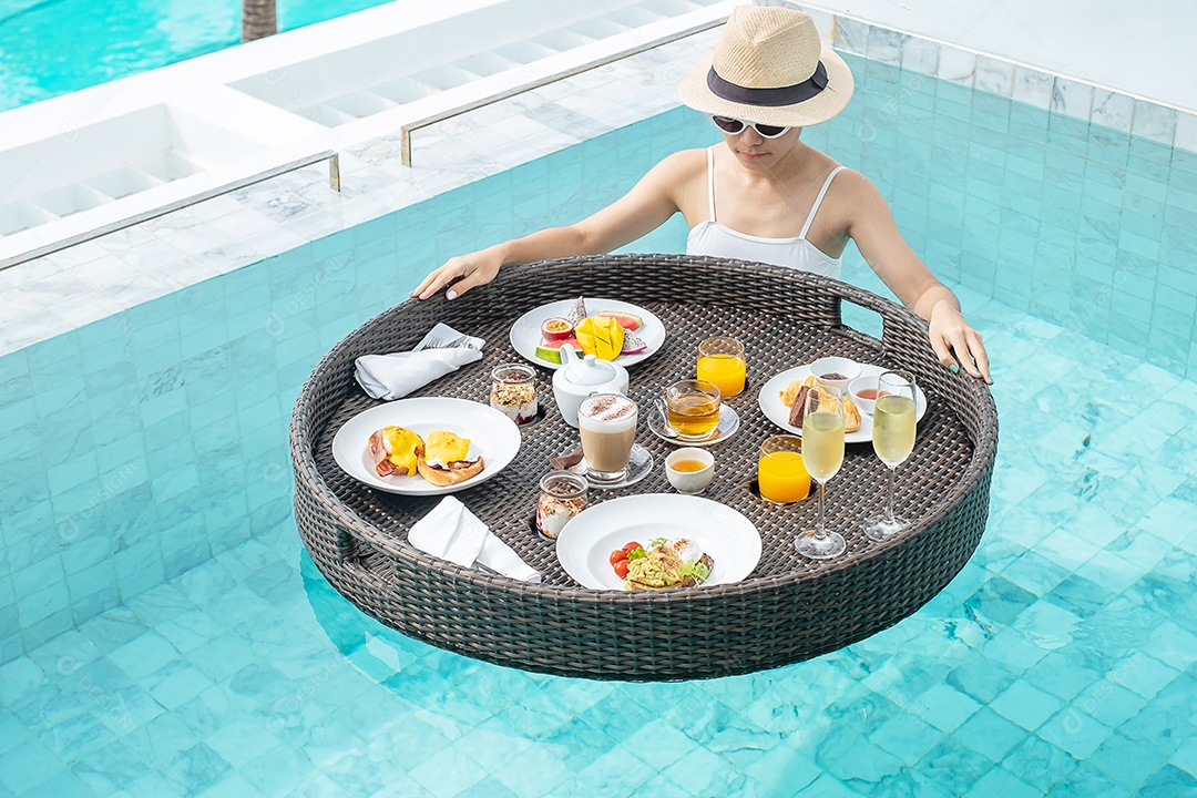 Mulher feliz em maiô branco com bandeja flutuante de café da manhã no hotel de piscina de luxo, jovem mulher com óculos de sol desfruta em resort tropical. Relaxante, viagens de verão exóticas, férias, férias e fim de semana