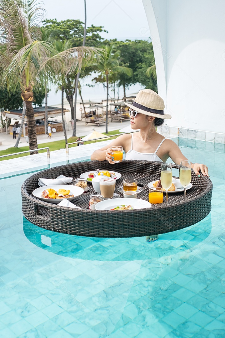 Mulher feliz em maiô branco com bandeja flutuante de café da manhã no hotel de piscina de luxo, jovem mulher com óculos de sol desfruta em resort tropical. Relaxante, viagens de verão exóticas, férias, férias e fim de semana