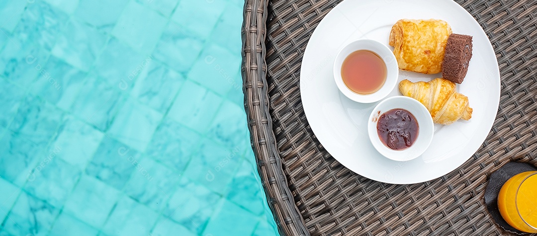 Bandeja flutuante de café da manhã na piscina no hotel de luxo ou villa de resort tropical, sobremesas; croissant, rocambole de chocolate, torta e suco de laranja. Viagens exóticas de verão, férias e conceito de férias