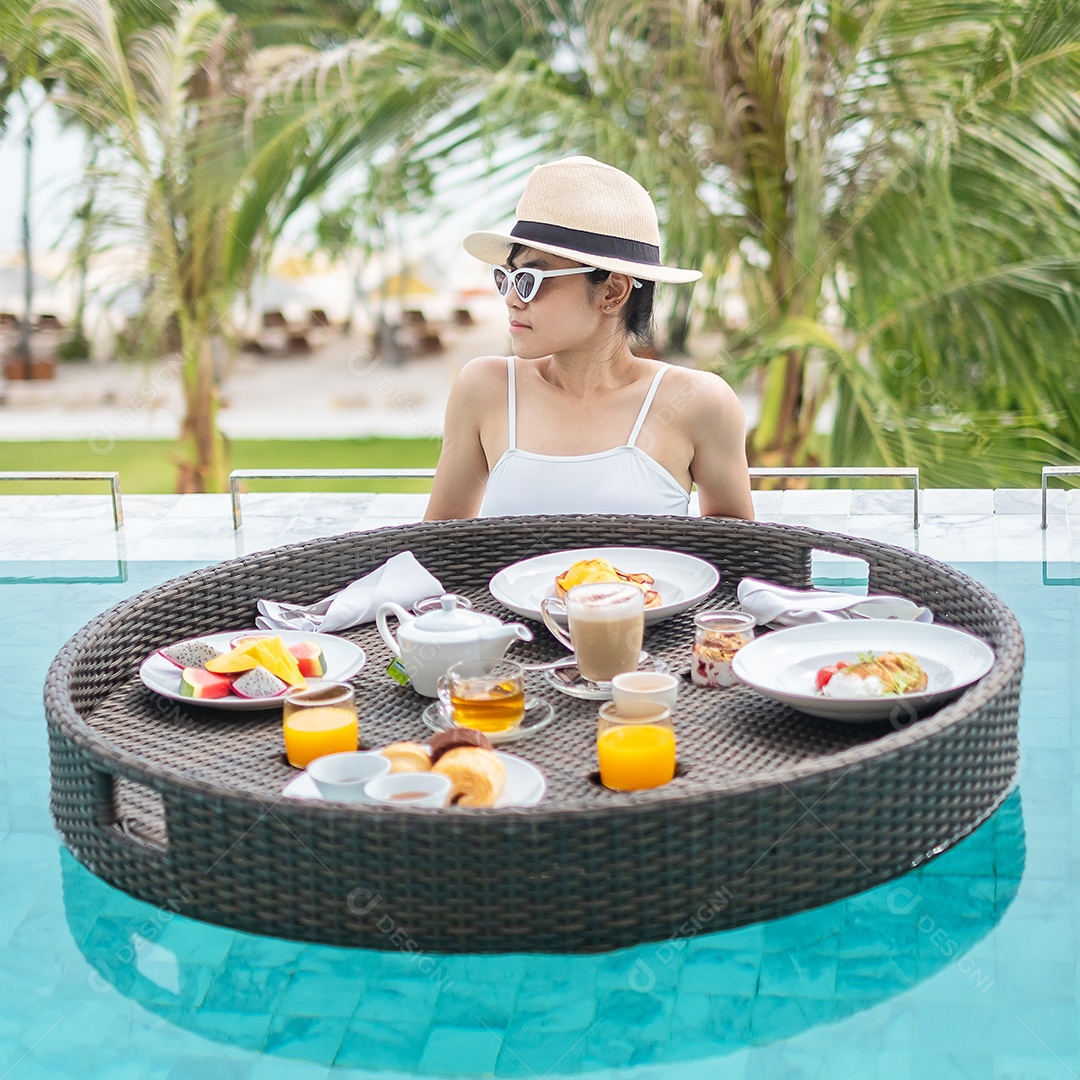 Mulher feliz em maiô branco com bandeja flutuante de café da manhã no hotel de piscina de luxo, jovem mulher com óculos de sol desfruta em resort tropical. Relaxante, viagens de verão exóticas, férias, férias e fim de semana