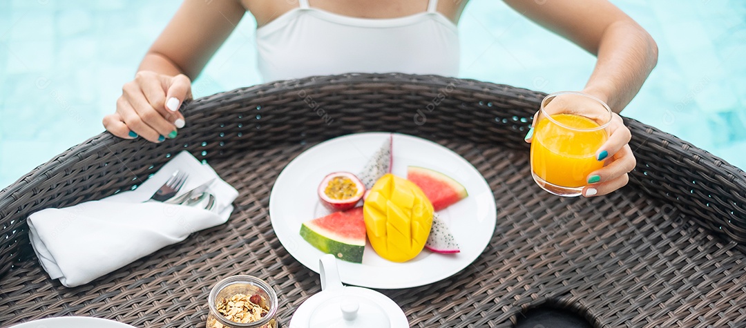 Mulher feliz em maiô branco com bandeja flutuante de café da manhã no hotel de piscina de luxo, jovem fêmea com prazer em resort tropical. Relaxante, viagens de verão exóticas, férias, férias e fim de semana