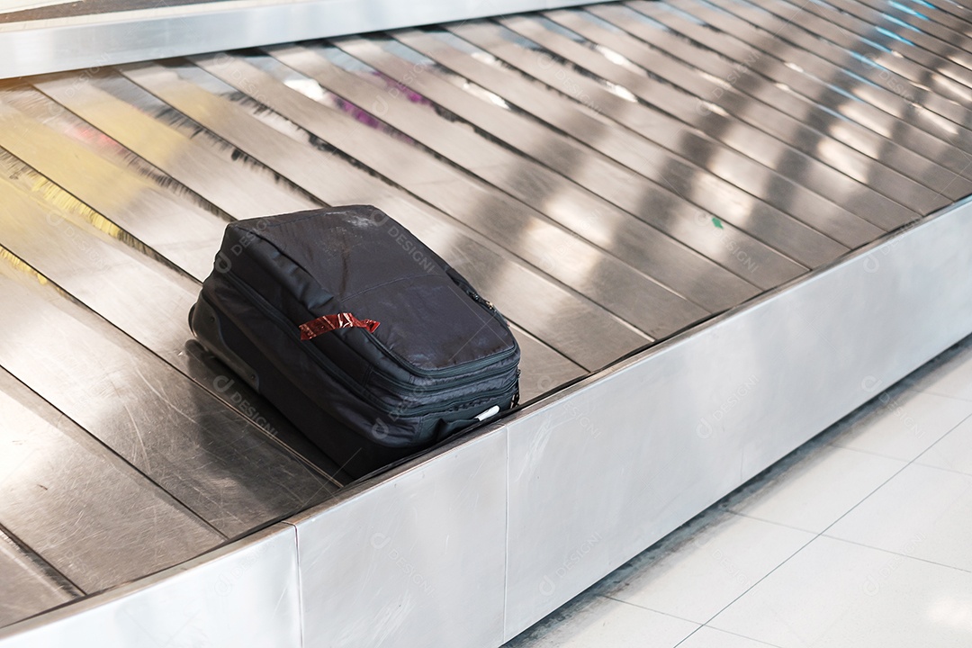 Saco de bagagem ou mala na correia transportadora no aeroporto internacional.