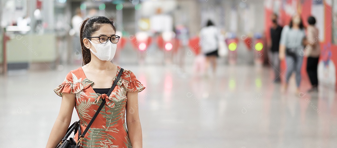 Jovem garota asiática usando máscara facial cirúrgica protege a inflexão de coronavírus, turista feliz andando na estação de metrô pública. distanciamento social, novo normal e vida após a pandemia de covid-19