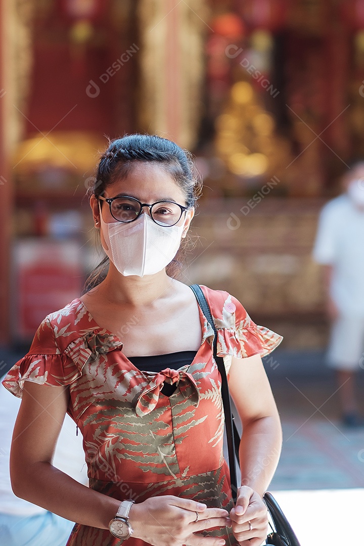 Jovem garota asiática usando máscara facial protetora protege a inflexão de coronavírus, turista feliz no novo estilo de vida normal após a pandemia de covid-19