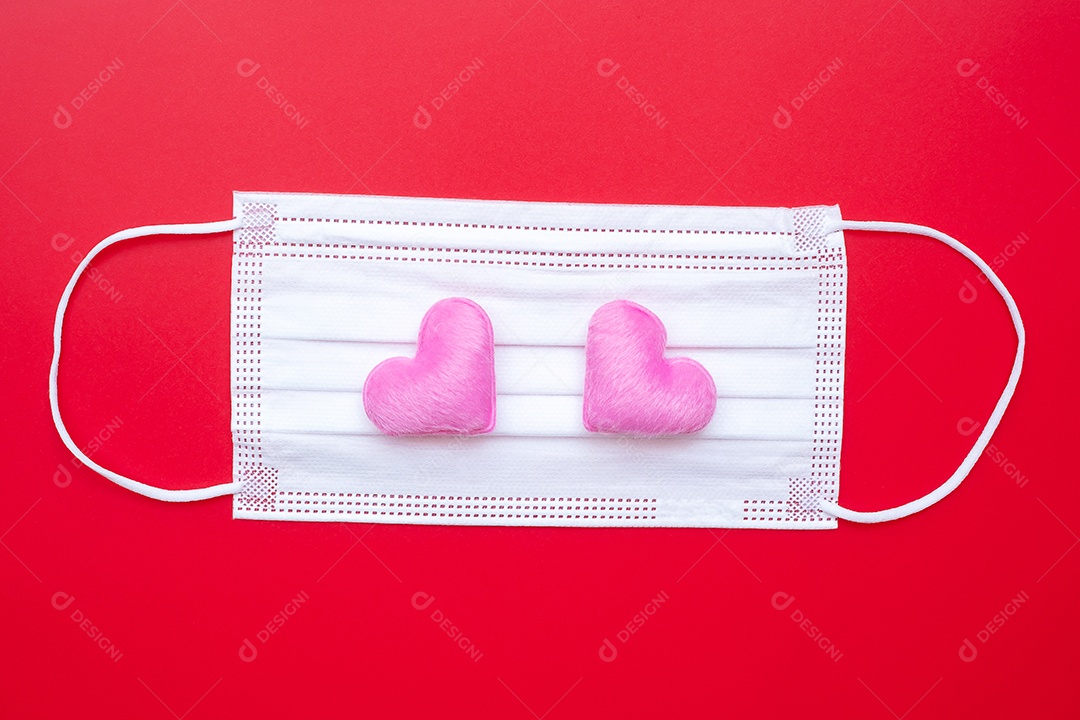 Decoração em forma de coração e máscara facial médica em fundo vermelho contra infecção por doença de coronavírus. Amor, juntos e feliz dia dos namorados sob o conceito de pandemia Covid-19
