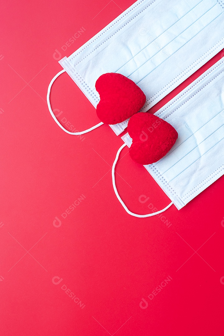 Decoração em forma de coração e máscara facial médica em fundo vermelho contra infecção por doença de coronavírus. Amor, juntos e feliz dia dos namorados sob o conceito de pandemia Covid-19