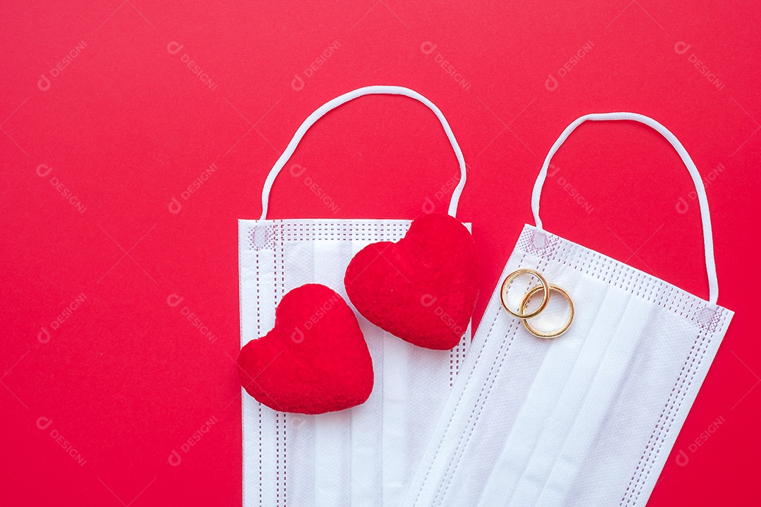 Decoração em forma de coração, anel de noivado dourado e máscara facial médica em fundo vermelho contra infecção por doença de coronavírus. Amor, juntos e feliz dia dos namorados sob o conceito de pandemia Covid-19