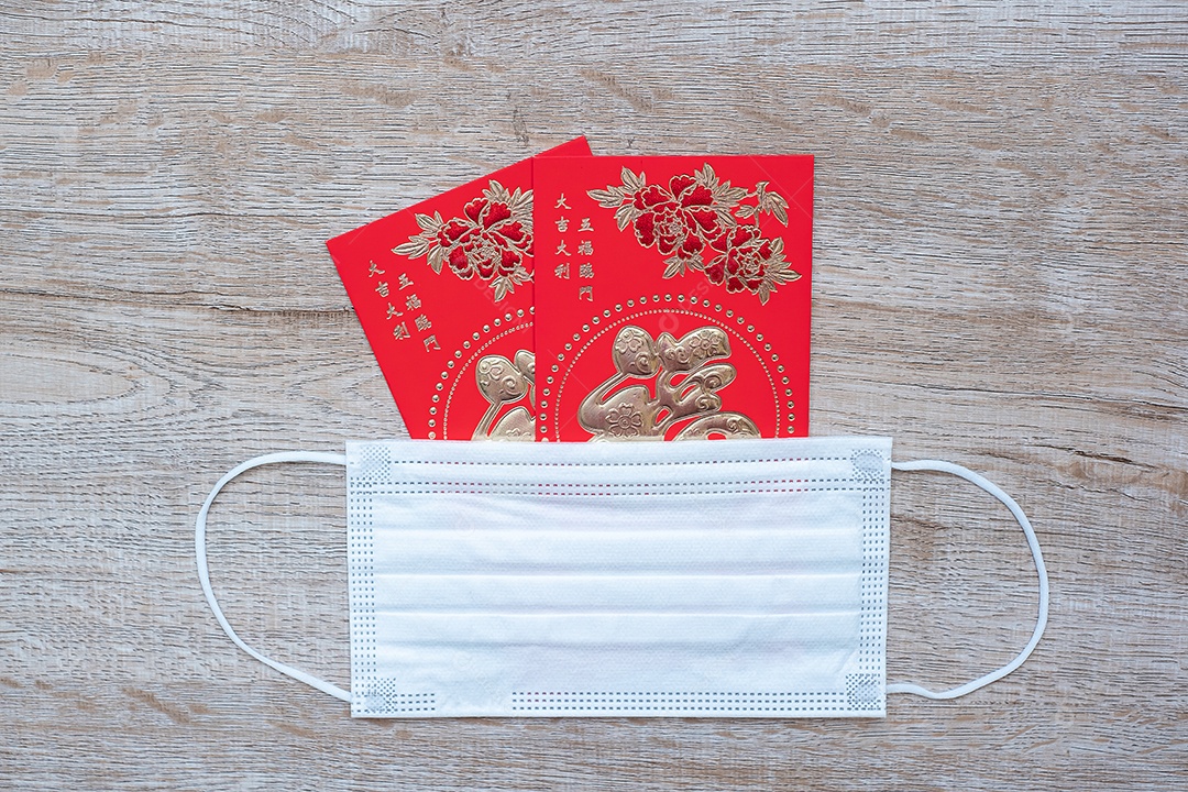 Envelope vermelho ou Ang pao e máscara facial médica contra infecção por doença de Coronavirus. O caractere chinês significa felicidade ou boa sorte, e a frase chinesa significa sorte e riqueza. Ano Novo Lunar