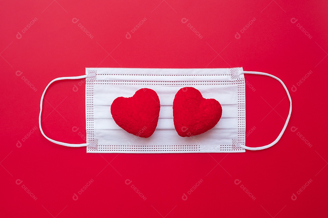 Decoração em forma de coração e máscara facial médica em fundo vermelho contra infecção por doença de coronavírus. Amor, juntos e feliz dia dos namorados sob o conceito de pandemia Covid-19