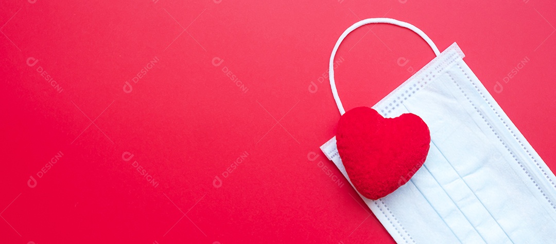 Decoração em forma de coração e máscara facial médica em fundo vermelho contra infecção por doença de coronavírus. Amor, juntos e feliz dia dos namorados sob o conceito de pandemia Covid-19
