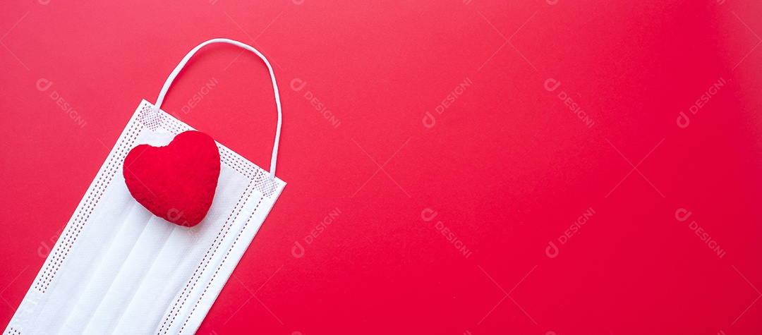 Decoração em forma de coração e máscara facial médica em fundo vermelho contra infecção por doença de coronavírus. Amor, juntos e feliz dia dos namorados sob o conceito de pandemia Covid-19