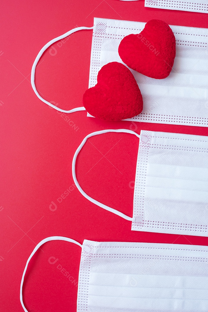 Decoração em forma de coração, anel de noivado dourado e máscara facial médica em fundo vermelho contra infecção por doença de coronavírus. Amor, juntos e feliz dia dos namorados sob o conceito de pandemia Covid-19