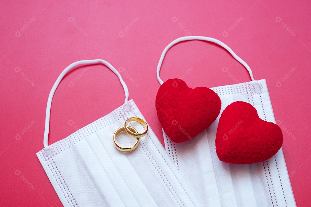 Decoração em forma de coração, anel de noivado dourado e máscara facial médica em fundo vermelho contra infecção por doença de coronavírus. Amor, juntos e feliz dia dos namorados sob o conceito de pandemia Covid-19