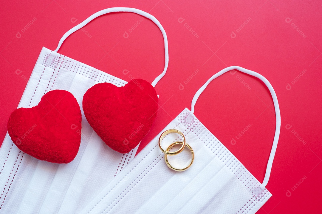 Decoração em forma de coração, anel de noivado dourado e máscara facial médica em fundo vermelho contra infecção por doença de coronavírus. Amor, juntos e feliz dia dos namorados sob o conceito de pandemia Covid-19