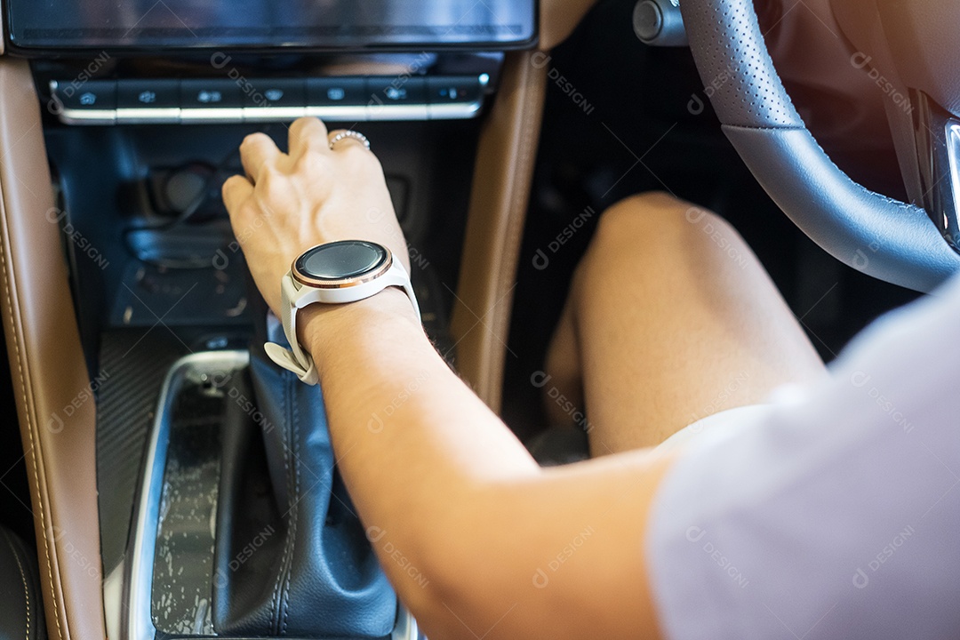 Motorista de mulher dirigindo um carro na estrada, mão controlando o volante no automóvel elétrico moderno. Conceitos de viagem, viagem e transporte