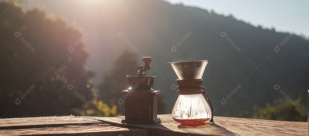 Café arábica quente e equipamento de gotejamento de café Vintage em mesa de madeira pela manhã com fundo de montanha e natureza