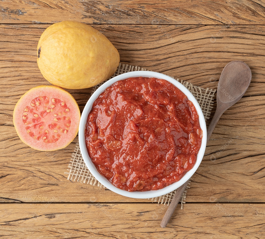 Goiabada, doce de goiaba cremosa brasileira tradicional com frutas sobre a mesa de madeira.