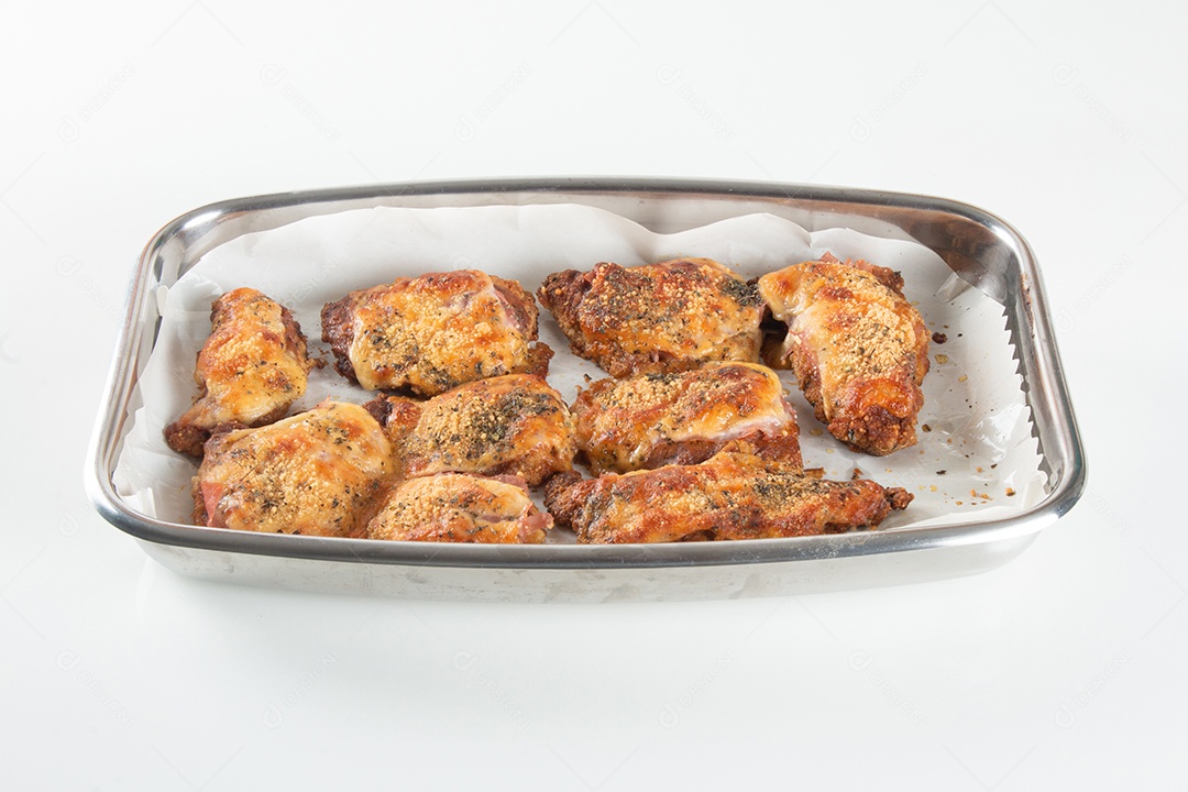 Assadeira com pedaços de frango assado cobertos de queijo.